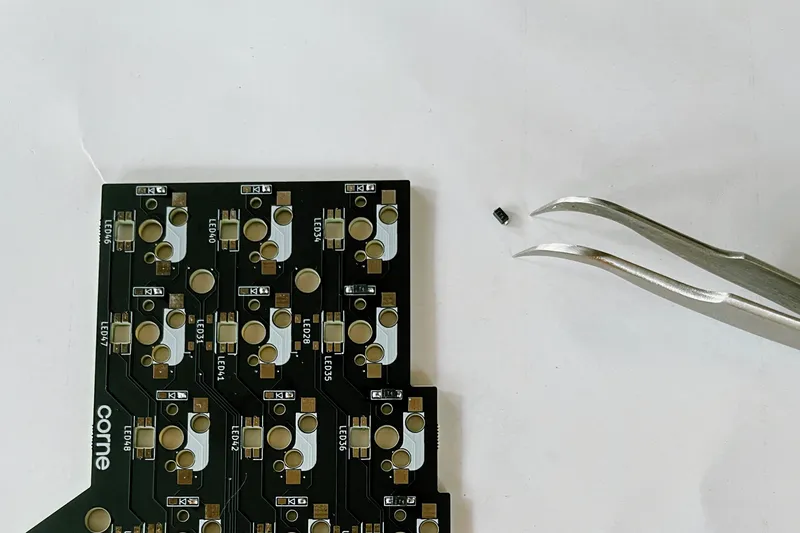 The size of a diode compared to the tip of the tweezer and the PCB